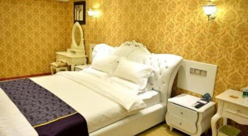 a bedroom with a large white bed and a mirror at GreenTree Inn Xian Longshouyuan Subway Station Business Hotel in Xi'an