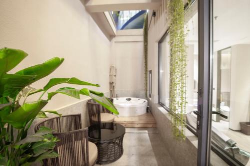 a bathroom with a white tub and plants at Suzhou Qingfeng Mingyue Hotel in Yinshanhunongchang