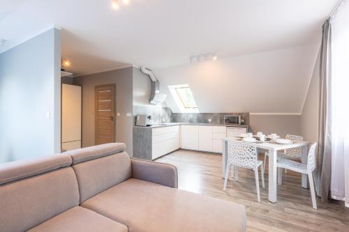 una sala de estar con un sofá y una mesa en Apartament Sosnówka B2 morsowanie i SPA, en Sosnówka