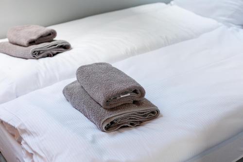 2 asciugamani sono seduti sopra un letto di Apartament Sosnówka B2 basen i SPA a Sosnówka