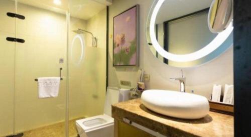 a bathroom with a sink and a toilet and a mirror at Lavande Hotels Suzhou Railway Station in Suzhou