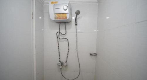 a shower in a bathroom with a phone on the wall at OYO Living 3091 Apt The Suites Metro By Ananda in Bandung