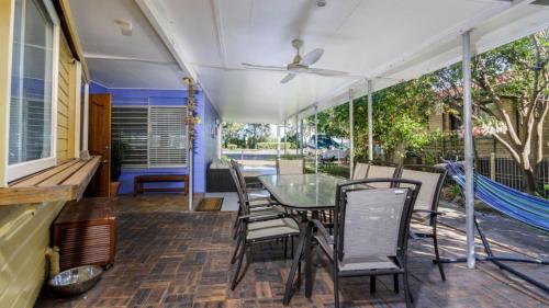 a screened porch with a glass table and chairs at Bribie Beach House, Waterfront directly across the road - Solander Esp, Banksia Beach in Old Bribie