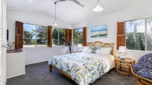 a bedroom with a bed and windows at Bribie Beach House, Waterfront directly across the road - Solander Esp, Banksia Beach in Old Bribie