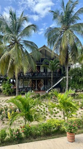 a house with two palm trees in front of it at Hotel Las Marias by Croma in Palomino