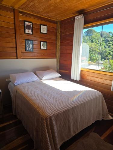 a bed in a room with a window at Casa temporada Grecco Vidal in Venda Nova do Imigrante