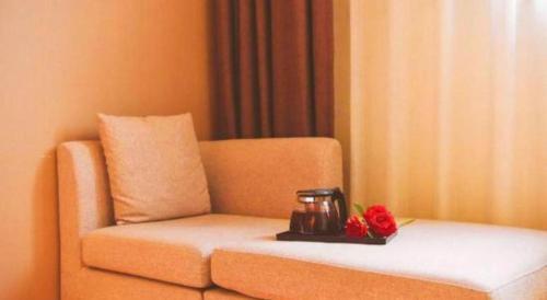 a couch with a tea pot and flowers on a tray at 7 Days Premium Chongqing Longtou Temple North Railway Station Center in Chongqing