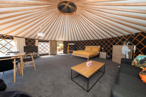 a living room with a yurt with a table and chairs at the hole in the rock yurt in Cape Foulwind