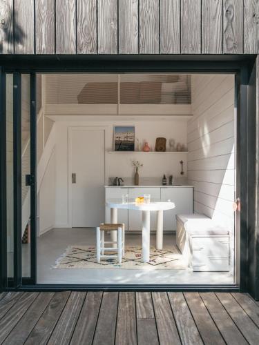 Cette chambre comprend une table blanche et un canapé. dans l'établissement Tiny House d'exception au bord de mer, à La Bernerie-en-Retz