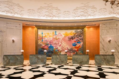 a room with chairs in front of a large painting at Grand Lisboa Palace Macau in Macau