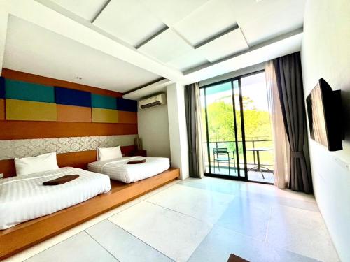 Un dormitorio con dos camas y una gran ventana. en Chalay Monta, en Hua Hin