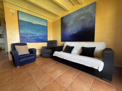 a living room with a couch and a chair at Los Sauces in Roses