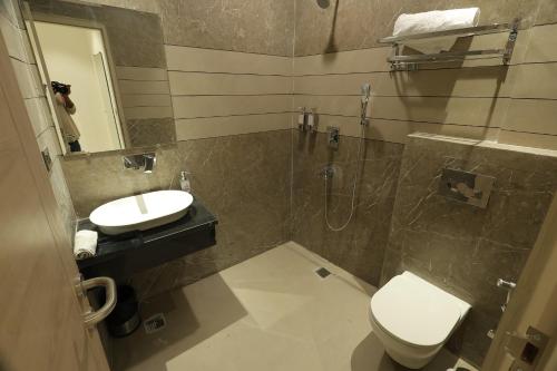 a bathroom with a toilet and a sink and a shower at Hotel Dreamz in Karnal
