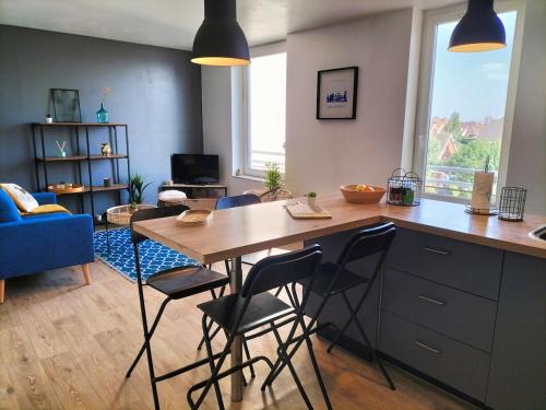 une cuisine avec une table et des chaises dans une pièce dans l'établissement Cosy T3 à 50 m de la plage, à Dunkerque