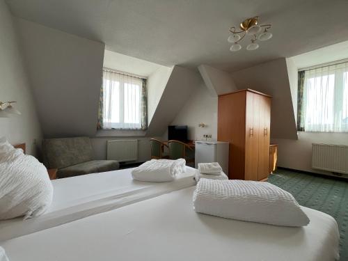 a bedroom with two beds and a living room at Aparthotel Mariazellerhof in Sankt Pölten