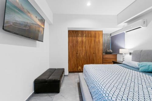 a bedroom with a bed and a tv on the wall at Ocean View - 2 King Size with Homeoffice Space in Mazatlán