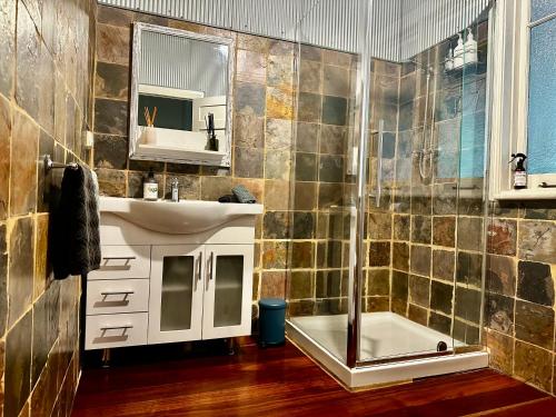 une salle de bain avec un lavabo et une douche dans l'établissement Hilltop Cottage, à Bridgetown