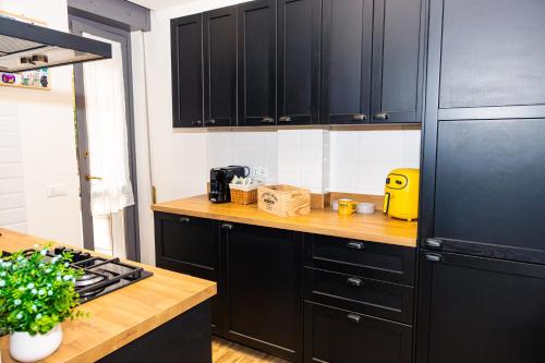 a kitchen with black cabinets and a black refrigerator at Casa Vacanza Via Roma in Iseo