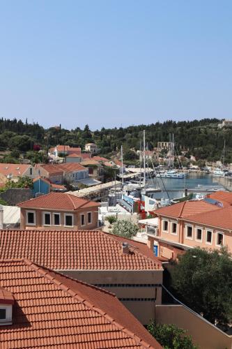a view of a town with red roofs and boats at Nafsika Apartments and Studios - Fiskardo in Fiskardho