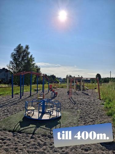 an empty playground with swings and slides in a field at Lino butai number 1 in Kalviai