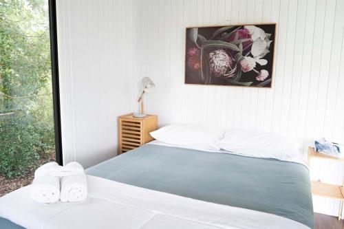 a bedroom with a bed with two towels on it at Hill Creek Tiny House 3 by Tiny Away in Perwillowen