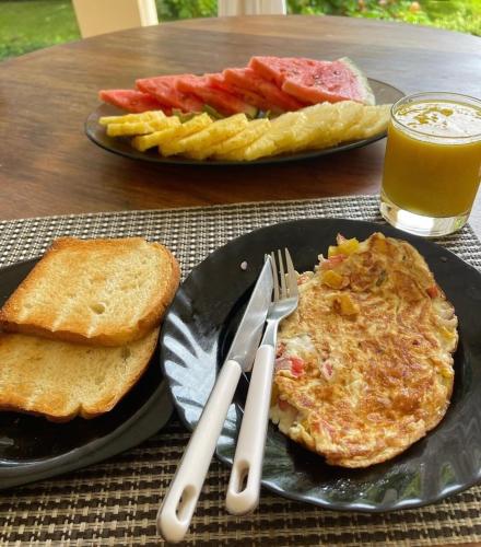 a table with a plate of breakfast food with eggs and toast at Your Seaside Home in Malindi