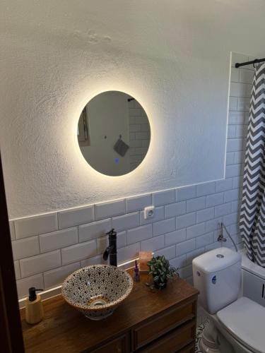 a bathroom with a sink with a mirror and a toilet at Living and feeling good in Burgbernheim