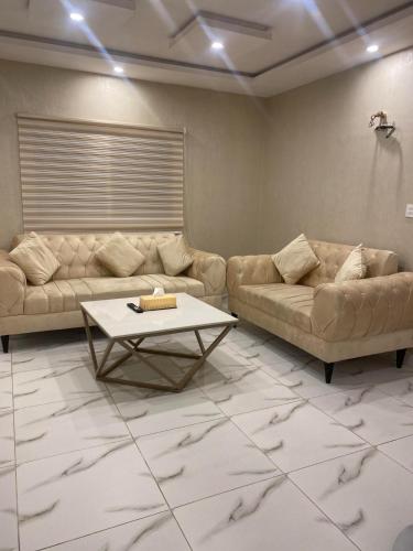a living room with two couches and a coffee table at WK Suites in Rāmkot