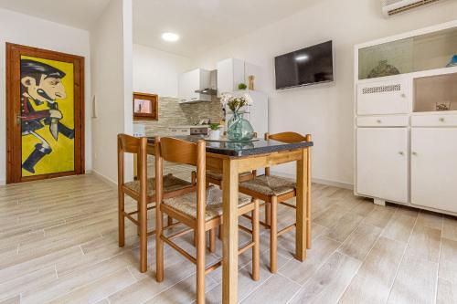 a kitchen with a table and chairs in a room at La Marina Guest House in Sorso