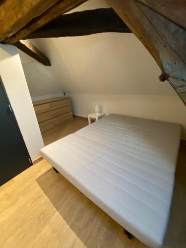 une chambre avec un lit blanc dans un grenier dans l'établissement Maison de charme face au Château de Langeais, à Langeais