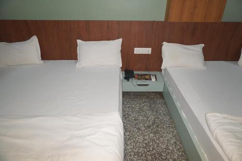two twin beds in a hotel room with at Hotel Dwarkadhish in Khātu