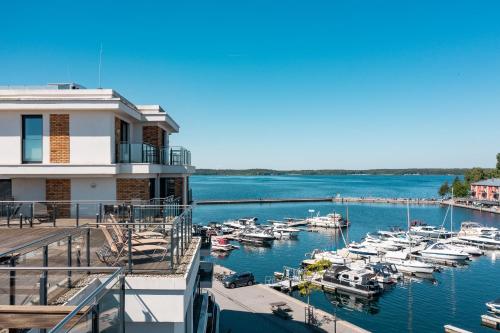 un puerto deportivo con barcos en el agua junto a un edificio en Müritz Utkiek - Apartment mit Seeblick & Balkon in der Hafenresidenz, en Waren