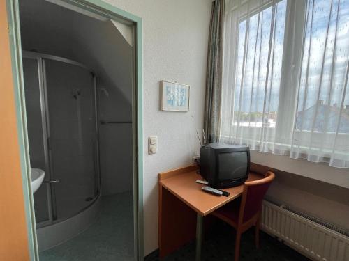 a room with a desk with a television and a window at Aparthotel Mariazellerhof in Sankt Pölten