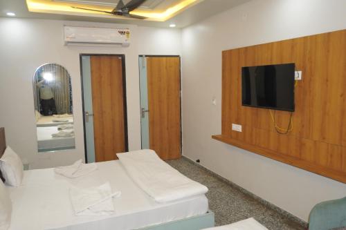 a room with a flat screen tv on a wall at Hotel Dwarkadhish in Khātu