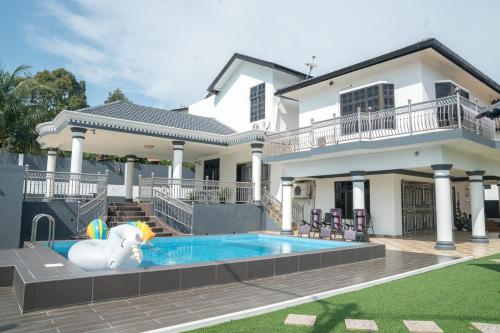 a house with a pool in front of a house at Impress Villa Homestay in Port Dickson