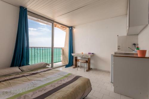 ein Schlafzimmer mit einem Bett und einem großen Fenster in der Unterkunft Porte Rouge 3 in Le Pradet