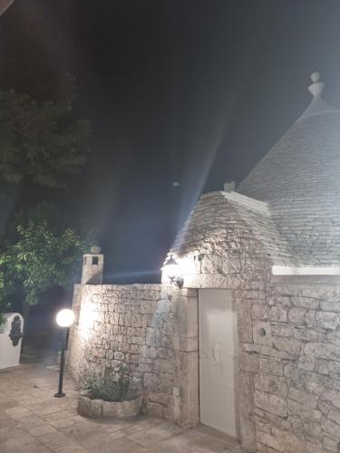 a stone building with a light on it at night at Avventure tra i trulli in Martina Franca