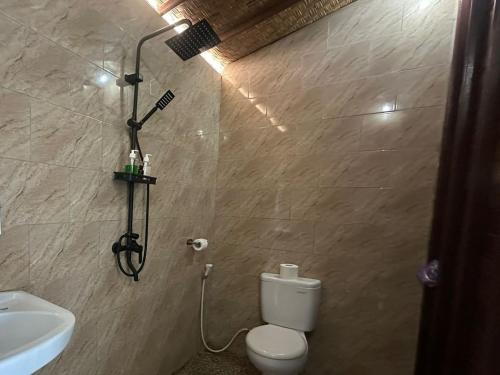 a bathroom with a white toilet and a sink at Blue Lagoon Secret Villas in Nusa Lembongan