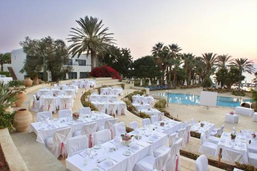 
a hotel room with tables, chairs and umbrellas at Azia Resort & Spa in Paphos
