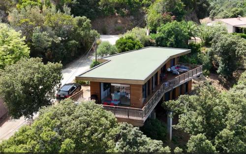 une vue de tête d'une maison avec une voiture garée devant dans l'établissement Villa l'Alpana en bois vue mer a 180 degres, à Sari-Solenzara