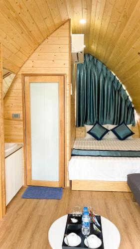 a small room with a bed and a table at Xanh Melody Resort in Bắc Ninh