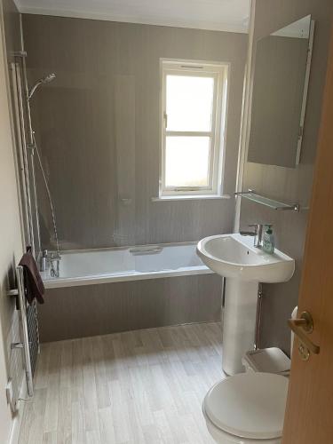 a bathroom with a sink and a tub and a toilet at Tullochwood Lodges in Forres