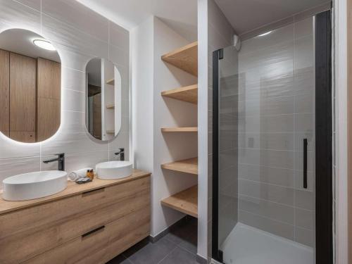 une salle de bain avec deux lavabos et une douche dans l'établissement Apt Art Mony 107 - BO Immobilier - Chatel, à Châtel