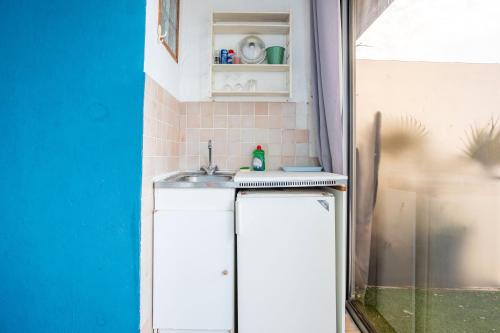 eine kleine Küche mit einem Waschbecken in einem Zimmer in der Unterkunft Jeux de boules 3 in Le Pradet