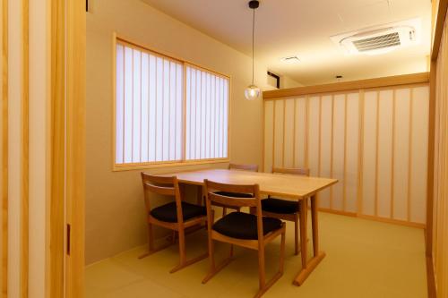 a dining room with a wooden table and chairs at YuhigauraOnsen Umi no Hana in Kyotango