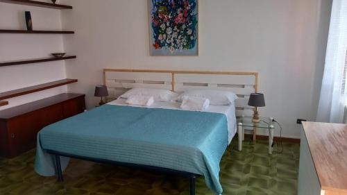 a bedroom with a bed with a blue blanket at My Holidays Bei Franca in Domaso