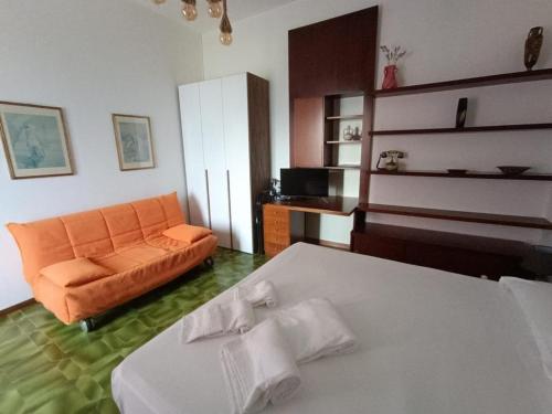 a living room with an orange couch and a bed at My Holidays Bei Franca in Domaso