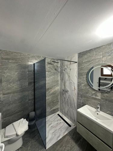 a bathroom with a shower and a sink and a mirror at Casa De Vacanță Maga Dubova in Dubova