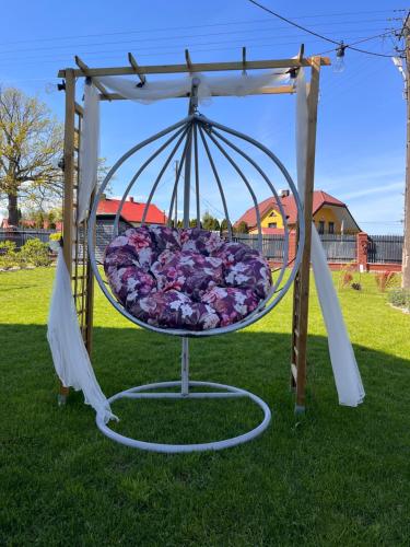 a swing with flowers on it in the grass at Pokoje Hotelowe "Lila" Siedlce in Siedlce
