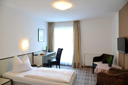 um quarto de hotel com uma cama e uma secretária em Arnimsruh Hotel garni em Lübeck